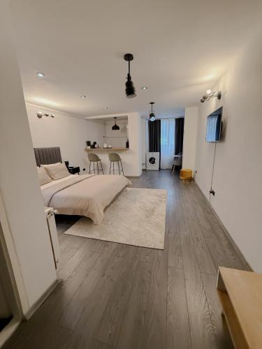 a white bedroom with a bed and a table at Signature Residence in Mediaş