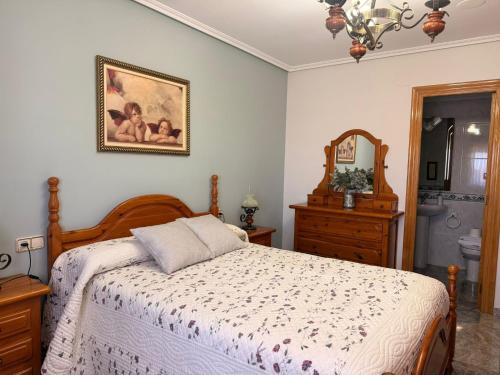 a bedroom with a bed and a dresser and a mirror at Casa Rural María Josefa in Bronchales