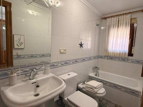 a bathroom with a sink and a toilet and a mirror at Casa Rural María Josefa in Bronchales