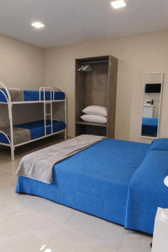 a bedroom with a blue bed and bunk beds at Rafinù B&B in Ercolano