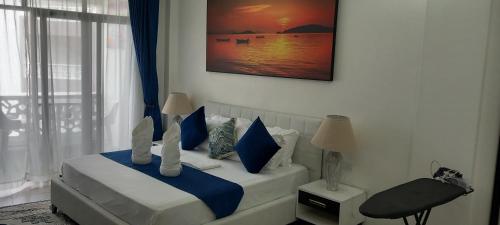 a bedroom with a bed with blue and white pillows at Easy stays baobab in Mombasa