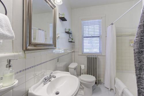 a bathroom with a sink and a toilet and a mirror at Beautiful Bungalow Stones throw from Cooper Young in Memphis