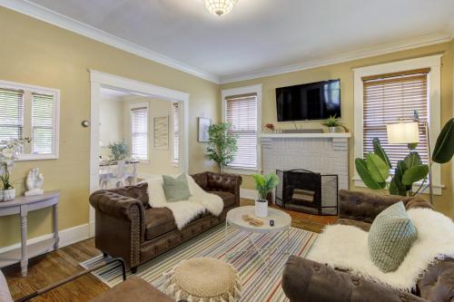 a living room with couches and a fireplace at Beautiful Bungalow Stones throw from Cooper Young in Memphis