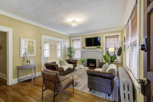 a living room with a couch and chairs and a tv at Beautiful Bungalow Stones throw from Cooper Young in Memphis
