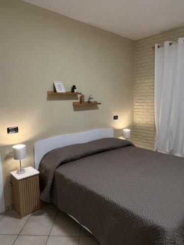 a bedroom with a bed and two shelves on the wall at Appartamenti Castel Ritaldi Il Sagrantino in Bruna