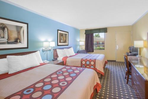 a hotel room with two beds and a television at Super 8 by Wyndham Jasper in Jasper