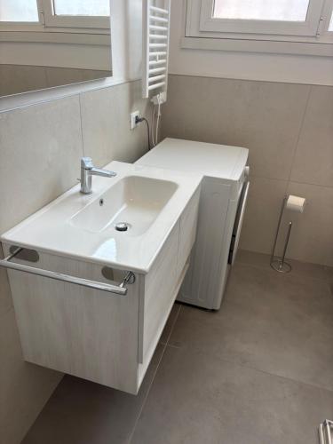 a white bathroom with a sink and a mirror at sweet rest in Castel Maggiore