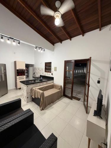 a living room with a bed and a ceiling fan at Casa luzes Amarelas in Caraguatatuba