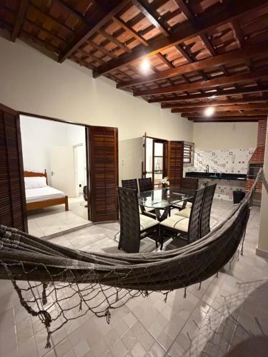 a hammock in a room with a table and chairs at Casa luzes Amarelas in Caraguatatuba