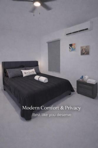 a bedroom with a black bed and a night stand at Modern Private Stay in Fajardo, PR - NEAR FERRY - BEACHES - EL YUNQUE - BIO BAY in Fajardo