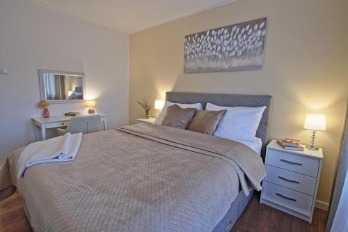 a bedroom with a large bed and a nightstand and a mirror at Luxury Apartment Ana in Otočac