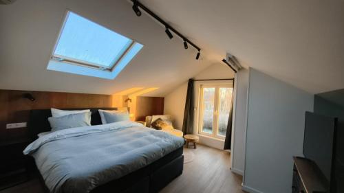 a bedroom with a bed with a skylight and a window at Cetti's Lodge - met privé sauna in Nieuwkoop