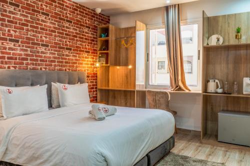 a bedroom with a large bed with a brick wall at Wow Hotel Dakhla Gym, Free Jacuzzi & Breakfast Included in Dakhla