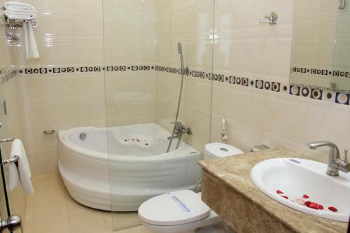 a bathroom with a tub and a toilet and a sink at Tran Vinh Hotel in Bạc Liêu