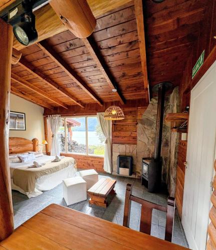 a bedroom with a bed and a fireplace in a room at Cabañas Walnor in Villa Traful