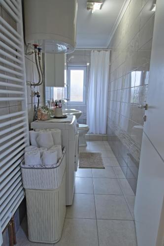a white bathroom with a sink and a toilet at Luxury Apartment Ana in Otočac