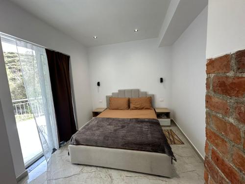 a bedroom with a bed and a brick wall at Qyteza guest house in Shkodër