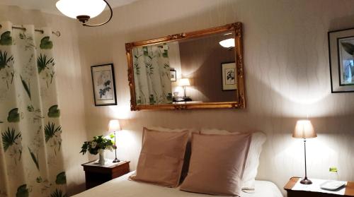 a bedroom with a bed with a mirror on the wall at La Renaissance Saint-Gervais-la-Forêt in Saint-Gervais-la-Forêt