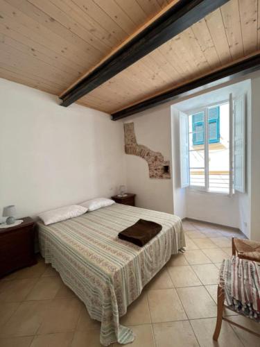 a bedroom with a bed and a large window at Appartamento vacanze Loano in Loano