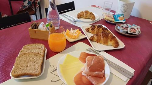 a table with plates of food and bread and orange juice at B&B Monté in Montesilvano