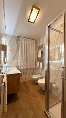 a bathroom with a tub and a sink and a toilet at Vittorio Emanuele Hotel in Sciacca