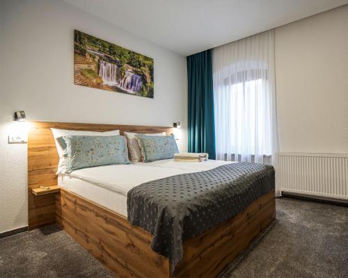 a bedroom with a large wooden bed with a window at Boutique Hotel Una in Sarajevo