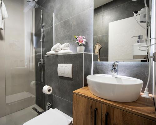 a bathroom with a sink and a toilet and a tub at Boutique Hotel Una in Sarajevo