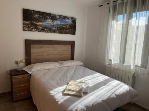 a bedroom with a bed with a book on it at Mil Mariposas, Escapada rural Burgos in Barriosuso