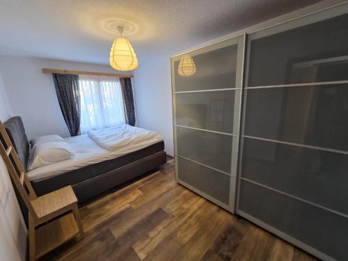 a small bedroom with a bed and a glass closet at Ferienwohnung mit Ausblick in Summaprada