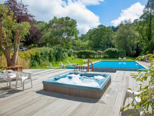 a hot tub sitting on a deck next to a pool at Tuckenhay, Mill Leat - Fcv in Ashsprington