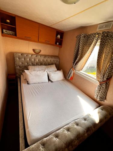 a small bed in a small room with a window at Kings caravan park A-27 in Skegness