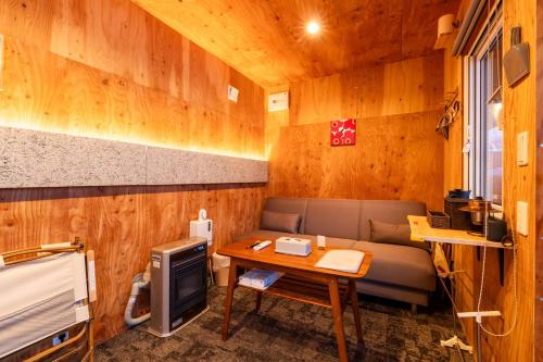 a living room with a couch and a table at SAUNA and VILLA Takibi in Makkari