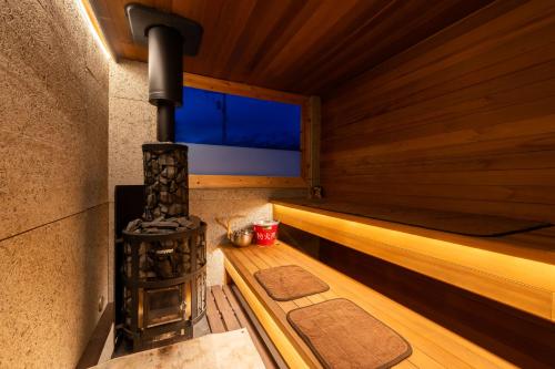 a sauna with a fireplace and a flat screen tv at SAUNA and VILLA Takibi in Makkari