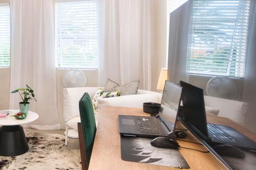 a desk with two computers on it in a living room at Stylish, Private, Thoughtful, Spotless, Aircon, Parking in Hermanus