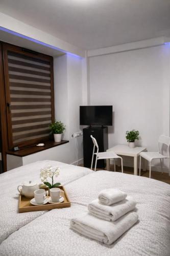 a hotel room with a tray of towels on a bed at Via Room in Raszyn