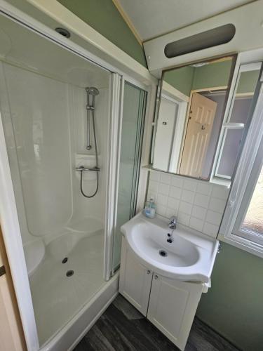 a bathroom with a white sink and a shower at V10 static caravan in Ingoldmells