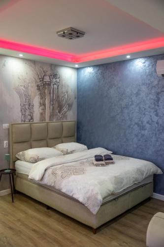 a bedroom with a bed with a painting on the wall at Foča Apartman STORY in Foča