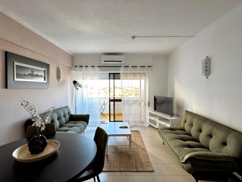 a living room with a couch and a table at Sea House Apartment - Private Condo with 4 Pools, Jacuzzi & Tennis Court in Albufeira