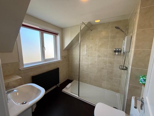 a bathroom with a shower and a sink and a toilet at The Ullapool Rooms in Ullapool