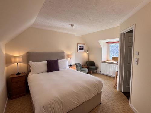 a bedroom with a large bed and a window at The Ullapool Rooms in Ullapool