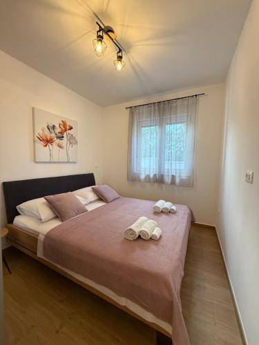 a bedroom with a large bed with towels on it at Apartman Lovor in Primošten