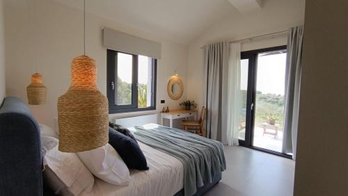 a bedroom with a bed and a large window at Villa GEIA in Klísmata