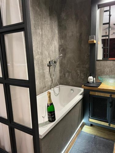a bathroom with a bottle of champagne sitting on a bath tub at Apartmány Veronika - Blansko in Blansko