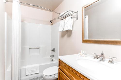 een badkamer met een wastafel, een toilet en een spiegel bij Days Inn by Wyndham Wurtsboro in Wurtsboro