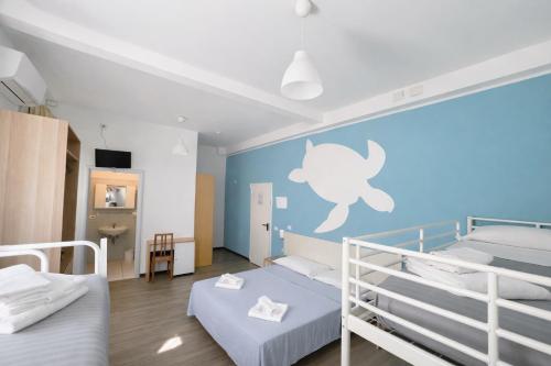a bedroom with two bunk beds and a blue wall at Hotel Aloha dipendenza Villa Silvie Rose in Cesenatico