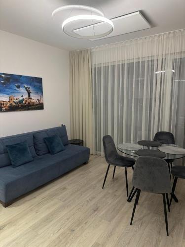a living room with a blue couch and a table at Fly & Pool Apartment in Palanga