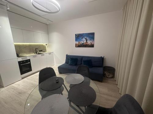 a living room with a couch and a table and chairs at Fly & Pool Apartment in Palanga