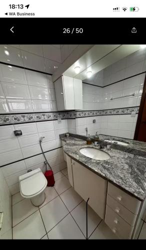 a bathroom with a sink and a toilet and a mirror at KS lazer e eventos in Ribeirão Preto