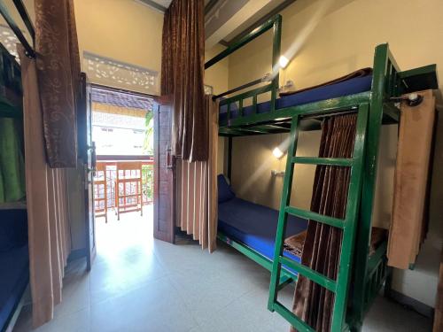 a room with two bunk beds and a doorway at ERA Guest House in Ubud