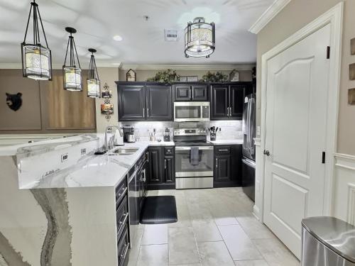 a kitchen with black cabinets and white appliances at Serenity at the Summit in Gatlinburg